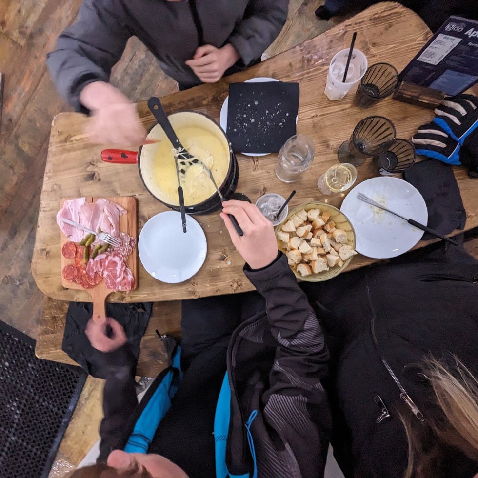 Стол распределен с фондю, вылеченным мясом и хлебом