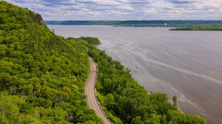 Дорога змеится вдоль реки Миссисипи летом.