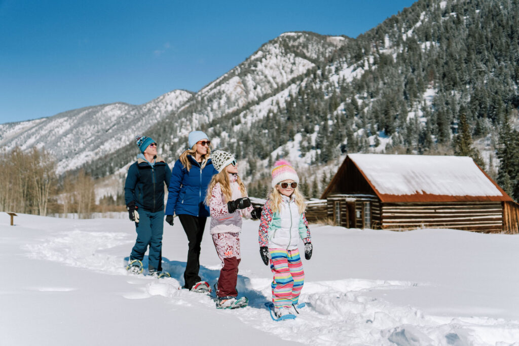 Семейная прогулка на снегоступах в солнечный день в Аспене