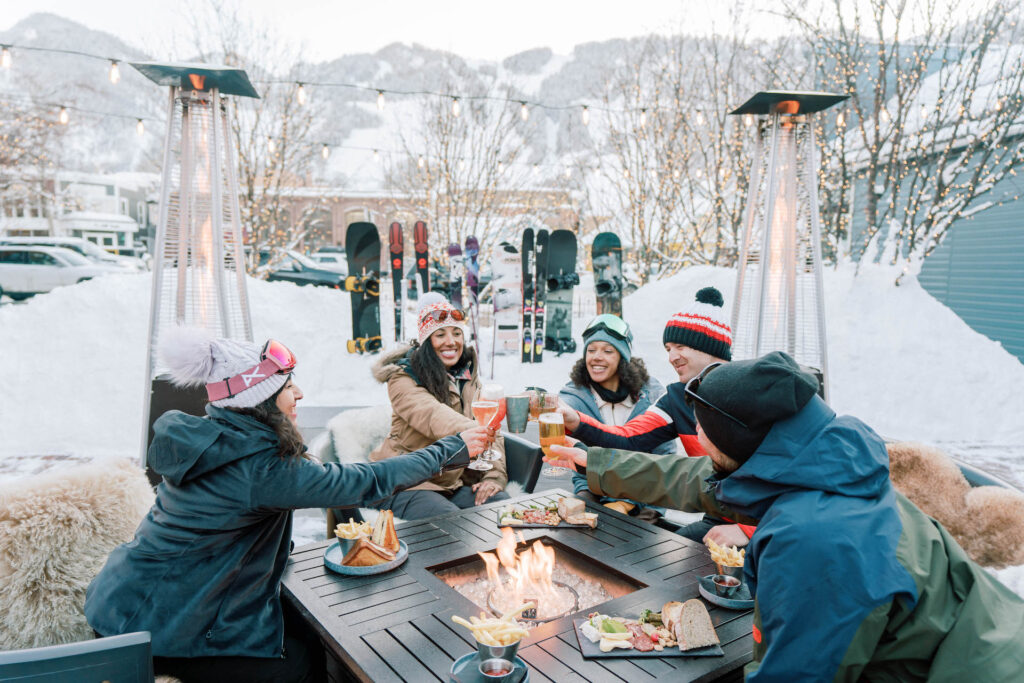 Друзья пьют бокалы во внутреннем дворике Аспена в зимний день