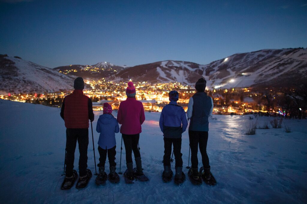 Семья с видом на Парк-Сити во время прогулки на снегоступах