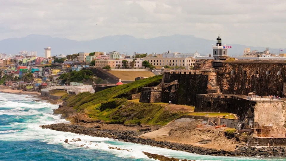 Старая крепость на красочном побережье Пуэрто-Рико со старыми и новыми городами.
