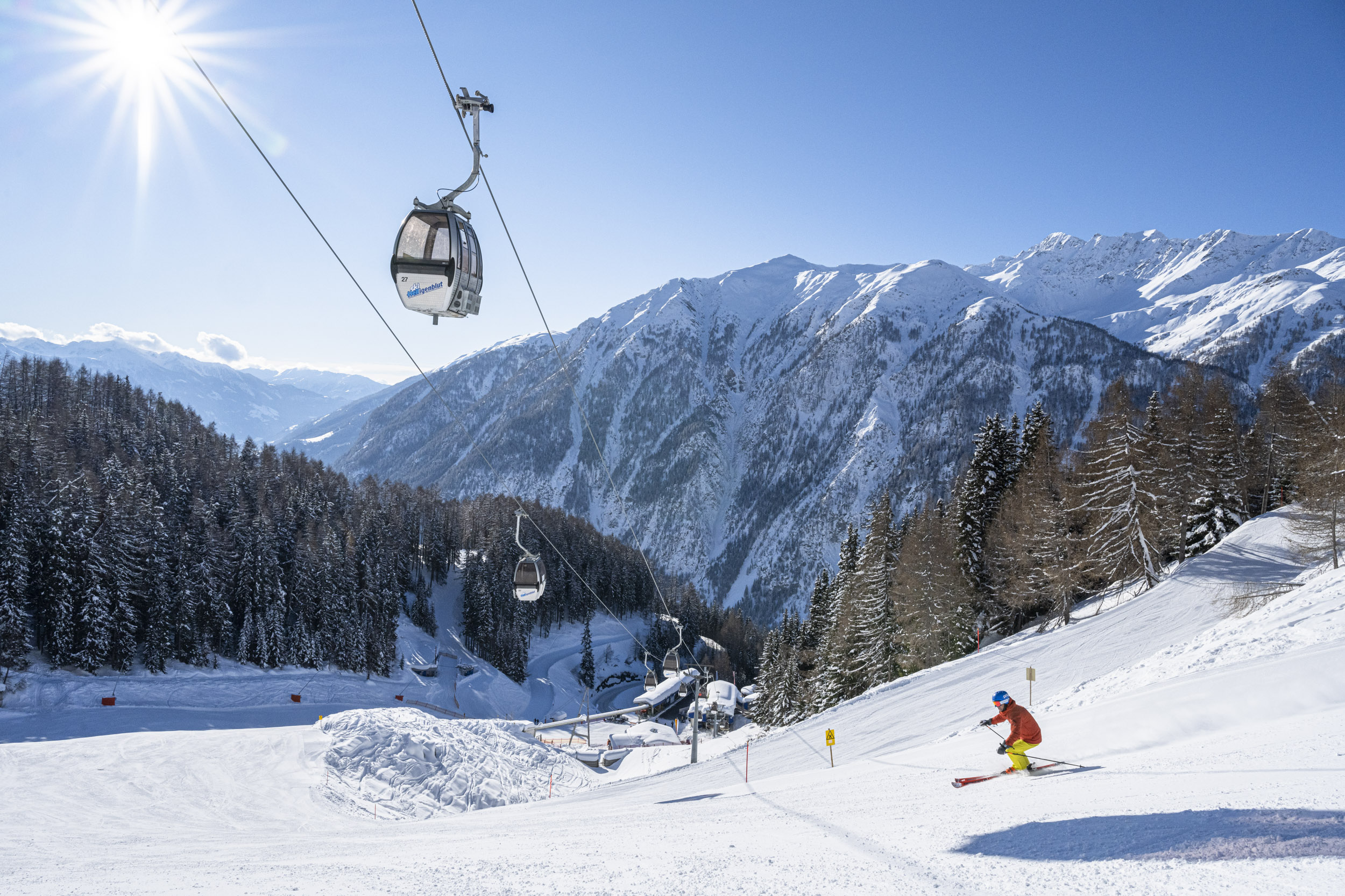 Лыжник на горе с канатной дорогой над Хайлигенблут-ам-Гросглокнер.