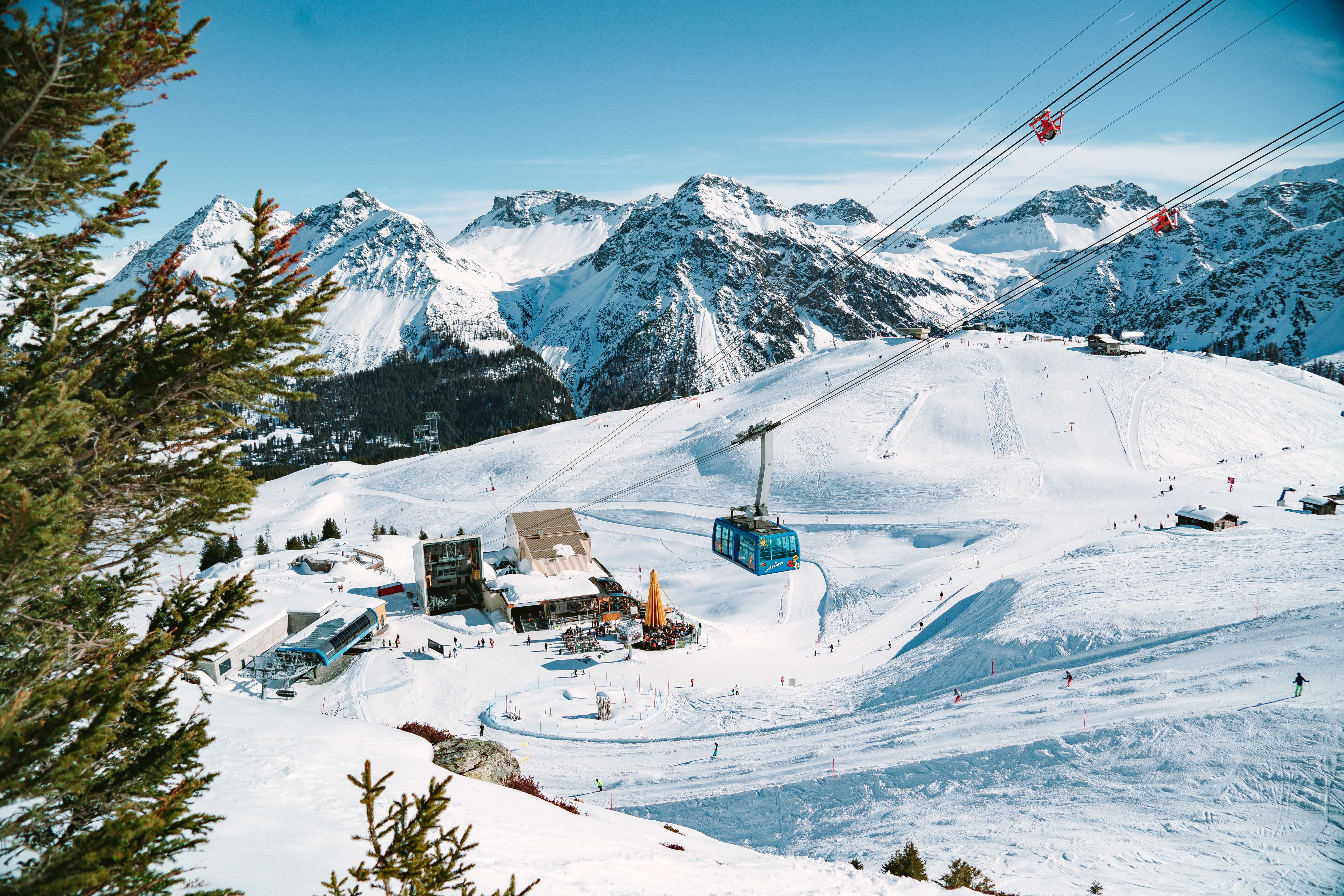 Лыжники и здания на горнолыжном курорте Ленцерхайде.