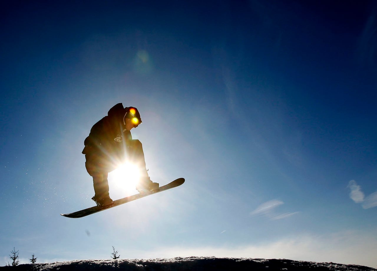 Сноубордист парит в воздухе, любуясь ярким солнечным голубым небом в среду, 21 февраля 2007 года, в лыжном и сноубордическом центре Глен Иден в Милтоне, Онтарио.